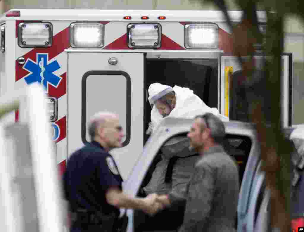 A person wearing a hazmat suit steps out of an ambulance as an Ebola patient arrives for treatment, Atlanta, Georgia, Sept. 9, 2014.