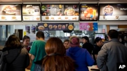 FILE - In this June 22, 2016 photo, customers stand in line at a fast food restaurant in Santiago, Chile. A new food labeling law went into effect on Monday in Chile, a country with the world's highest rates of childhood obesity. (AP Photo/Esteban Felix)