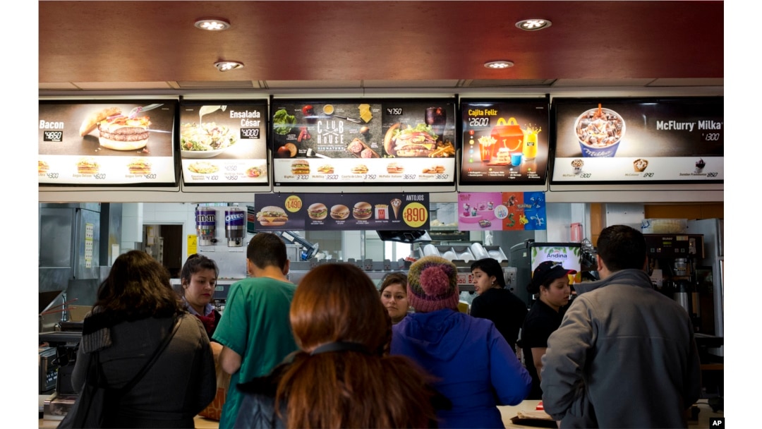 Customers stand in line at a fast food restaurant in Santiago, Chile, June 22, 2016.