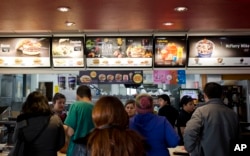 Customers stand in line at a fast food restaurant in Santiago, Chile, June 22, 2016.