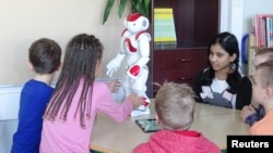 FILE - Students use a language-trainer robot, Elias, during their lesson at the school in Tampere, Finland, March 27, 2017.