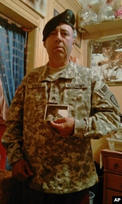 Sgt. Carde, who was wounded in Iraq, keeps a picture of his fallen comrade in his living room.