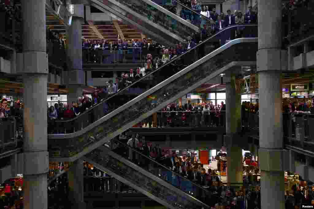 Staff members stand for a poppy drop during a Remembrance Service at the Lloyd&#39;s building in the City of London, Britain.