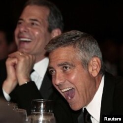 L'acteur George Clooney (à dr.) s'esclaffe en écoutant le président Obama.