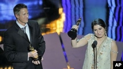 Daniel Junge (L) and Sharmeen Obaid-Chinoy accept the Oscar for best documentary short for 'Saving Face' during the 84th Academy Awards in the Hollywood section of Los Angeles, February 26, 2012.