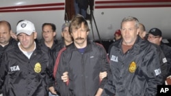 Suspected Russian arms dealer Viktor Bout (C) is escorted by Drug Enforcement Administration (DEA) officers after arriving at Westchester County Airport in White Plains, New York November 16, 2010.