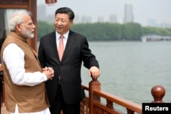 FILE - India's Prime Minister Narendra Modi speaks with Chinese President Xi Jinping as they take a boat ride on the East Lake in Wuhan, China, April 28, 2018.
