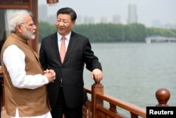 India's Prime Minister Narendra Modi speaks with Chinese President Xi Jinping as they take a boat ride on the East Lake in Wuhan, China, April 28, 2018.