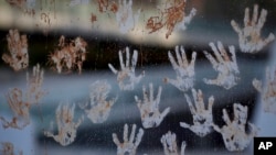 Mud hand prints are seen on a glass window, during a protest at the door of the Brazilian mining company Vale, in Rio de Janeiro, Brazil, Jan. 28, 2019. 