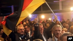 Supporters of the nationalist Alternative for Germany AfD celebrate after the state election in the German state of Hesse in Wiesbaden, Germany, Sunday, Oct. 28, 2018. (Frank Rumpenhorst/dpa via AP)