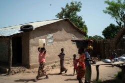 Lama Mballow carries a gallon of water collected from a local well at the Sare Gibel village in Bansang, Gambia, Sept. 29, 2021.