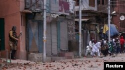 FILE - Demonstrators throw stones towards Indian police during clashes after the Eid al-Fitr prayers in Srinagar, India, June 5, 2019. 