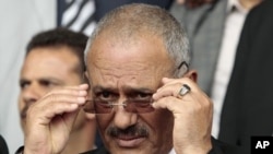 Yemen's President Ali Abdullah Saleh adjusts his glasses during a rally in Sana'a, April 22, 2011