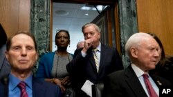 Sen. Lindsey Graham, R-S.C., center, arrives to speak at a Senate Finance Committee hearing to consider the Graham-Cassidy healthcare proposal, Sept. 25, 2017, in Washington. Also pictured is Ranking Member Sen. Ron Wyden, D-Ore., left, and Chairman Sen. Orrin Hatch, R-Utah, right.