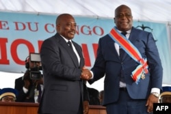 FILE - Democratic Republic of the Congo's outgoing President Joseph Kabila, left, shakes hands with newly inaugurated President Felix Tshisekedi after he was sworn-in in Kinshasa, Jan. 24, 2019.