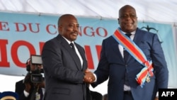 Le 24 janvier 2019, le président sortant de la République démocratique du Congo, Joseph Kabila, serre la main du président nouvellement élu, Felix Tshisekedi, après l'avoir assermenté à Kinshasa.