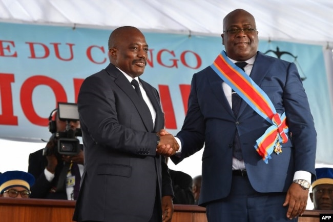 FILE - Democratic Republic of the Congo's outgoing President Joseph Kabila, left, shakes hands with newly inaugurated President Felix Tshisekedi after he was sworn-in in Kinshasa, Jan. 24, 2019.