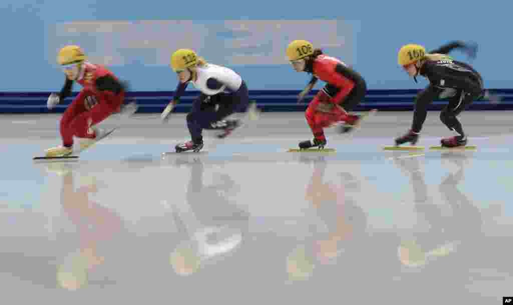 Fan Kexin of China, Elise Christie of Britain, Jessica Hewitt of Canada and Emily Scott of the United States compete in a women's 500m short track speedskating quarterfinal at the Iceberg Skating Palace, Feb. 13, 2014.