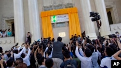 Journalists photograph the unveiling of the Yangon Stock Exchange at an opening ceremony in Yangon, Myanmar, Dec. 9, 2015. 
