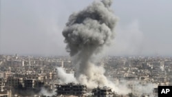 FILE - Smoke rises after shelling by the Syrian army, after Russian airstrikes, in Damascus, Syria, Oct. 14, 2015.