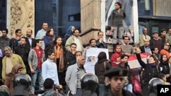 Des manifestants anti-gouvernementaux devant le siège du Syndicat des journalistes égyptiens, au centre du Caire, le 27 janvier 2011