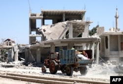 Residents flee the rebel-held town of Nawa in southern Syria, July 18, 2018.