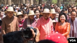In a rare public display of cooperation to start the "culture of dialogue", Cambodian opposition leader Sam Rainsy and prime minister Hun Sen and their wives participate in the Angkor Sangkranta-Khmer New Year festival in Siem Reap, Cambodia in April 2015.