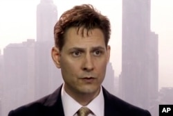 FILE -Image made from a video on March 28, 2018 shows Michael Kovrig, an adviser with the International Crisis Group, a Brussels-based non-governmental organization, speaking during an interview in Hong Kong.