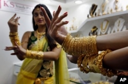 FILE - An Indian model displays gold jewelry during a Jewelry and Gem Fair in Hyderabad, India,.