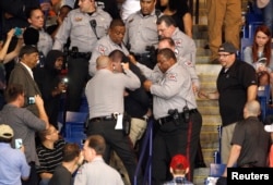 FILE - Police officers forcibly restrain a protester at U.S. Republican presidential candidate Donald Trump's campaign rally in Fayetteville, North Carolina, March 9, 2016.