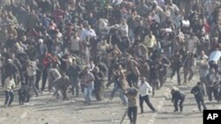 Pro-government demonstrators, below, and anti-government demonstrators, above, clash in Tahrir Square, the center of anti-government demonstrations, in Cairo, Egypt, February 2, 2011