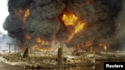 La fumée et les flammes sont aperçues après l’explosion d’un gazoduc saboté à Andoni, dans l'état de Rivers, au Nigeria, 20 décembre 2005.