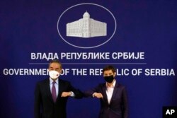 FILE - Serbian Prime Minister Ana Brnabic, right, welcomes Chinese Foreign Minister Wang Yi ahead of meeting at the Serbia Palace in Belgrade, Serbia, Oct. 27, 2021.