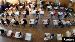 Para siswa yang baru lulus sekolah menengah mengikuti ujian masuk universitas di Strasbourg, Perancis. (Reuters/Vincent Kessler)