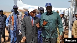 FILE - South Sudan's Oil minister Ezekiel Lul Gatkuoth (R) and Sudan's oil minister, Azhari Abdel Qader arrive for a ceremony marking the restarting of crude oil pumping at the Unity oil fields in South Sudan, Jan. 21, 2019. 