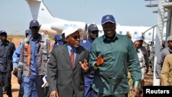 FILE - South Sudan's Oil minister Ezekiel Lul Gatkuoth (R) and Sudan's oil minister, Azhari Abdel Qader arrive for a ceremony marking the restarting of crude oil pumping at the Unity oil fields in South Sudan, Jan. 21, 2019. 