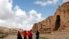 Perempuan Afghanistan berjalan di depan ceruk yang pernah terdapat patung Buddha raksasa, di Provinsi Bamiyan 21 April 2009. (Foto: REUTERS/Omar Sobhani)