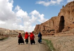 Perempuan Afghanistan berjalan di depan ceruk yang pernah diadakan patung Buddha raksasa, di provinsi Bamiyan 21 April 2009. (Foto: REUTERS/Omar Sobhani)