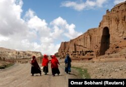 Perempuan Afghanistan berjalan di depan ceruk yang pernah diadakan patung Buddha raksasa, di provinsi Bamiyan 21 April 2009. (Foto: REUTERS/Omar Sobhani)
