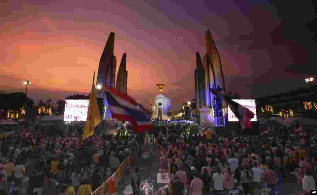 Anti-government protesters stand up to hear the national anthem at the Democracy Monument in Bangkok, &nbsp;Dec. 6, 2013.