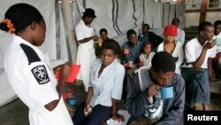 FILE - Cholera patients drink treated water inside an admission ward at Budiriro Polyclinic in Harare, Zimbabwe.