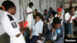 FILE - Cholera patients drink treated water inside an admission ward at Budiriro Polyclinic in Harare, Zimbabwe.