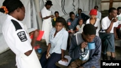 FILE - Cholera patients drink treated water inside an admission ward at Budiriro Polyclinic in Harare, Zimbabwe.