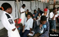 FILE - Cholera patients drink treated water inside an admission ward at Budiriro Polyclinic in Harare, Zimbabwe.