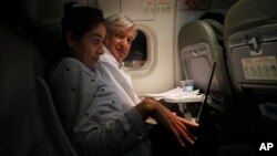 Mexican President Andres Manuel Lopez Obrador, center, sits with an assistant as he travels in economy class aboard a commercial flight from Guadalajara to Mexico City, March 9, 2019.