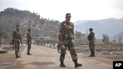 FILE - Indian army soldiers walk near the Line of Control (LOC) trade center at the Chakan Da Bagh, in Poonch, 245 kilometers northwest of Jammu, India, Jan. 14, 2013.