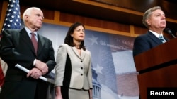 FILE - From left, Republican U.S. Senators John McCain of Arizona, Kelly Ayotte of New Hampshire and Lindsey Graham of South Carolina talk to reporters on Capitol Hill about legislation aimed at restricting prisoner transfers from Guantanamo Bay, Jan. 13, 2015.