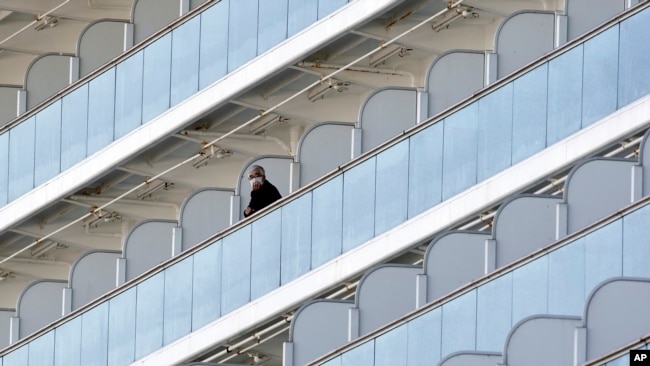 Un pasajero del crucero Diamond Princess, en cuarentena en el puerto de Yokohama, en Japón, observa desde un balcón el 6 de febrero de 2020.