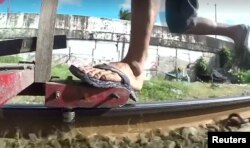 Manila's "trolley boys" push carts along 28-km (17-mile) of railroad track, most wearing flimsy flip-flops on their feet.