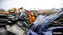 FILE - A young Rohingya refugee stands in her house which has been destroyed by Cyclone Mora at Balukhali Refugee Camp in Cox’s Bazar, Bangladesh.